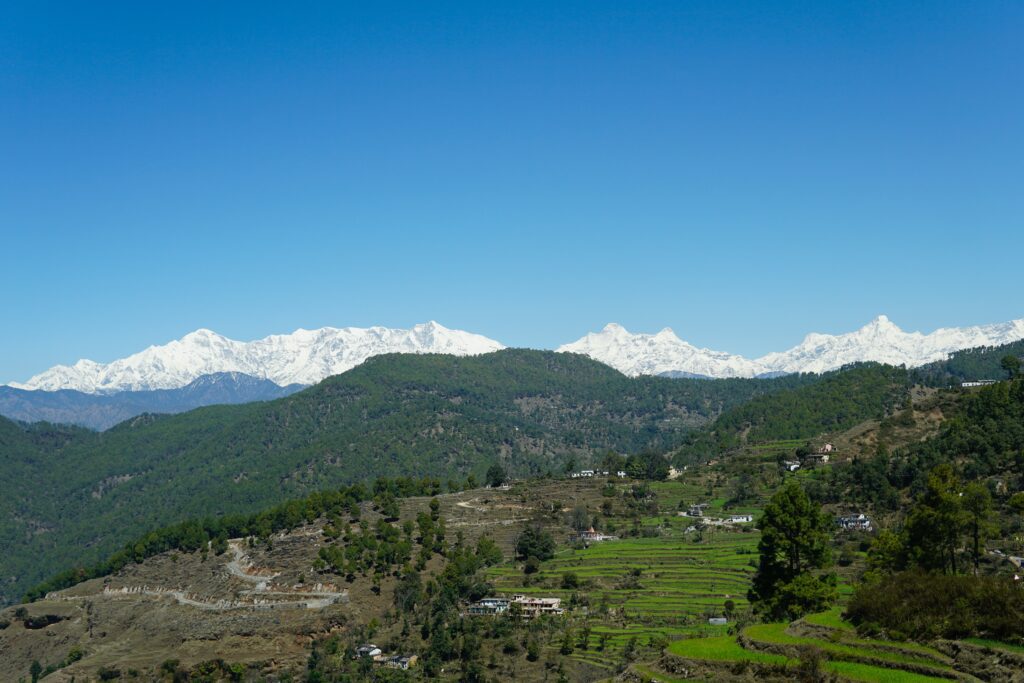 Green Valley With Backdrop of Snow Clad Mountains