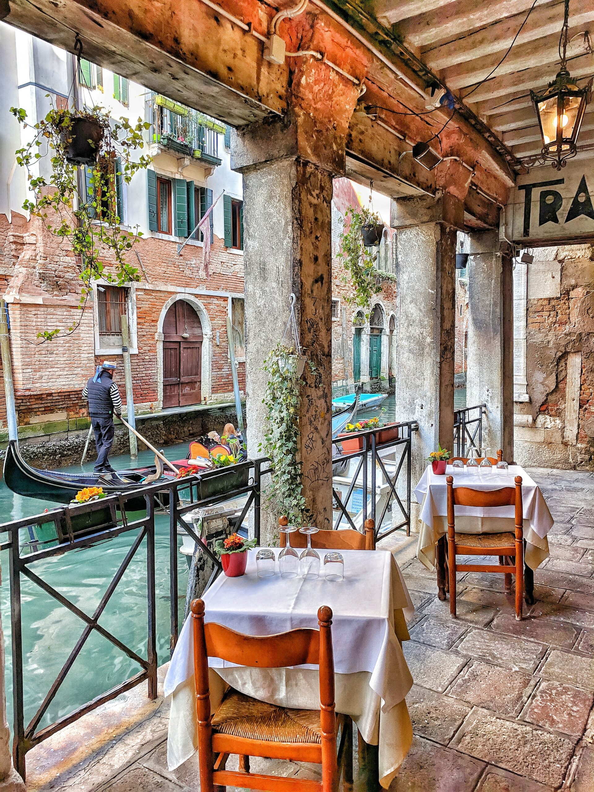 Italy People Riding in a Boat Passing by a Restaurant in Venice